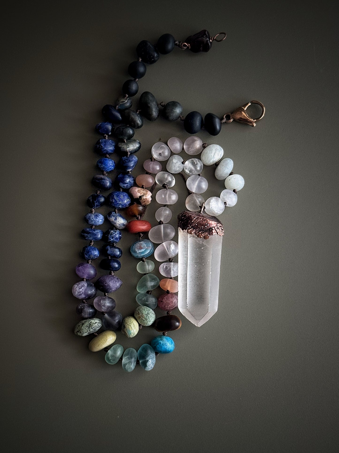 Dettaglio della collana con pietre naturali opache e ciondolo a punta di quarzo ialino lavorato in rame – Ebbijoux