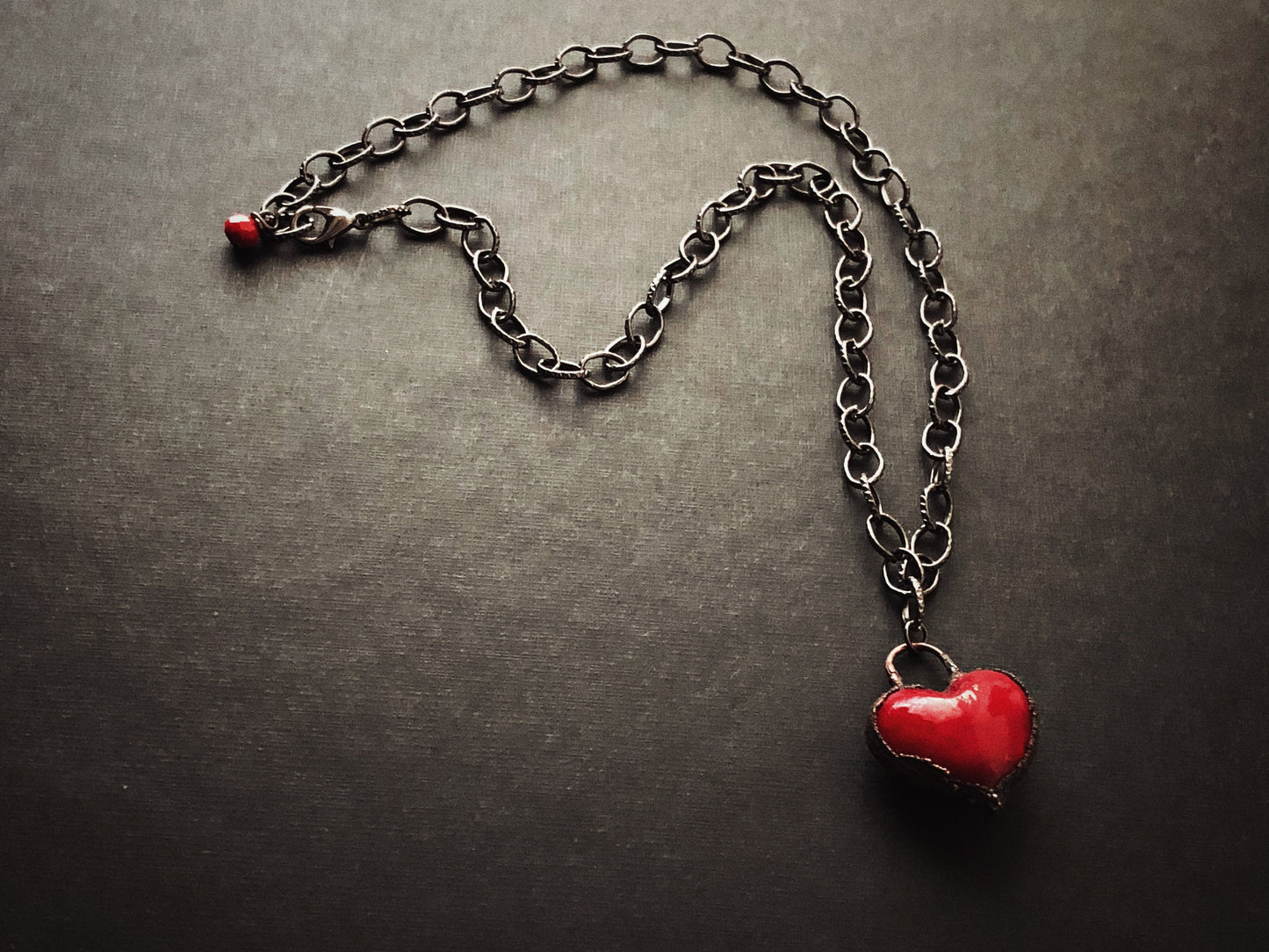 Collana iconica con cuore rosso intenso.