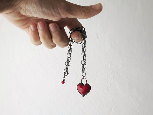 Collana iconica con cuore rosso intenso.