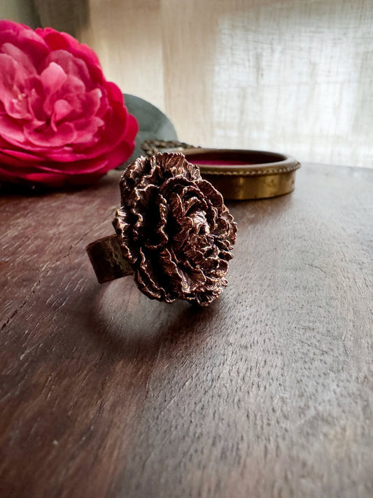 Anello con fiore in rame brunito.