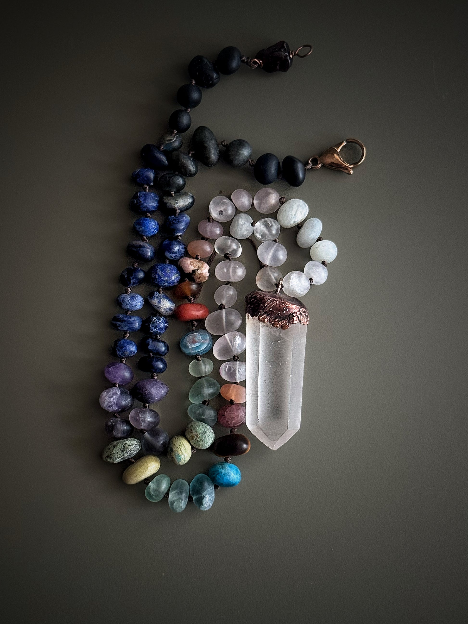 Dettaglio della collana con pietre naturali opache e ciondolo a punta di quarzo ialino lavorato in rame – Ebbijoux