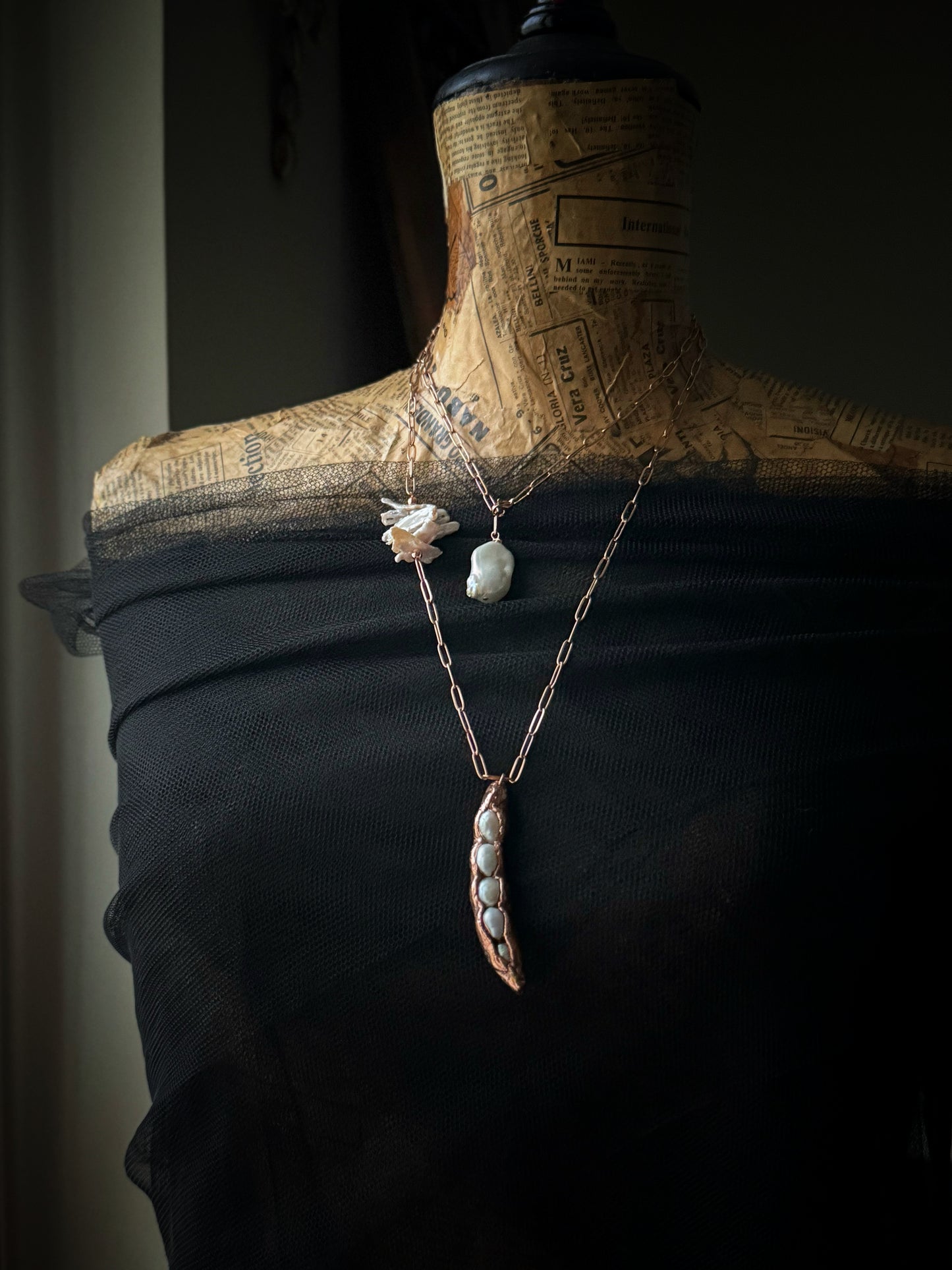 Ciondolo in rame con cinque perle in un baccello