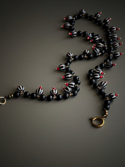 Dettaglio dei ciondoli in Agata Dzi e perle di Ossidiana con vetro rosso e chiusura placcata oro – Ebbijoux