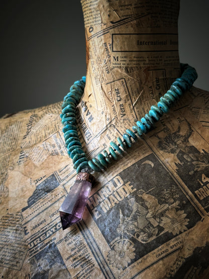 Dettaglio del girocollo in turchese e punta di ametista indossato su manichino vintage con carta di giornale – Ebbijoux