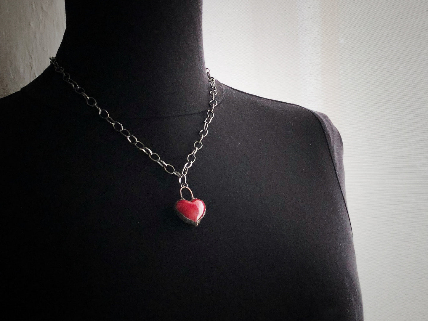 Collana iconica con cuore rosso intenso.