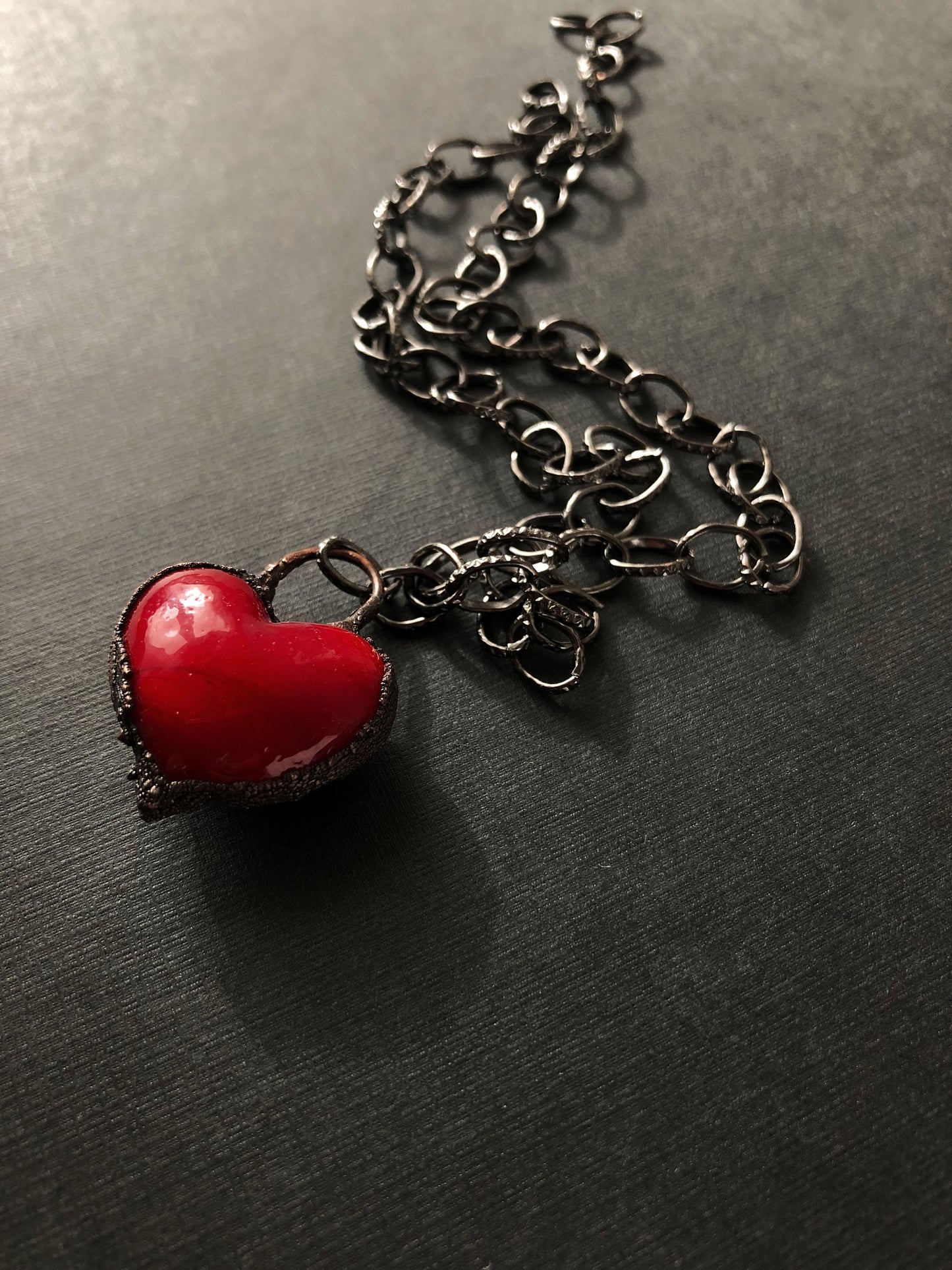 Collana iconica con cuore rosso intenso.
